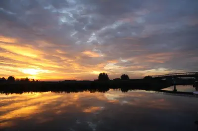 a sunset over a body of water with a bridge at Trek-in in IJsselstein