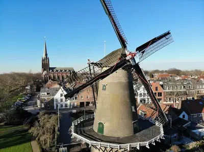 an old windmill in a town with a church at Trek-in in IJsselstein
