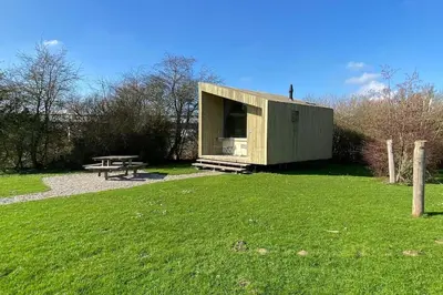 a small shed with a picnic table in a field at Trek-in in IJsselstein