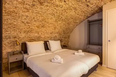 a bed in a room with a brick wall at Luxurious renovated apartment in Utrecht City center with view on the old canal in Utrecht