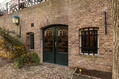 a brick building with a green door and windows at Luxurious renovated apartment in Utrecht City center with view on the old canal in Utrecht