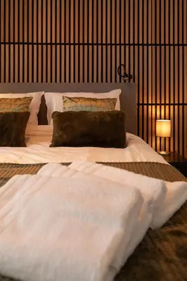 a large bed with white sheets and pillows in a bedroom at Woonboot De Rietpieper in Loosdrecht