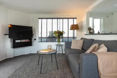a living room with a couch and a tv at Woonboot De Rietpieper in Loosdrecht