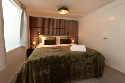 a bedroom with a large bed with a large window at Woonboot De Rietpieper in Loosdrecht