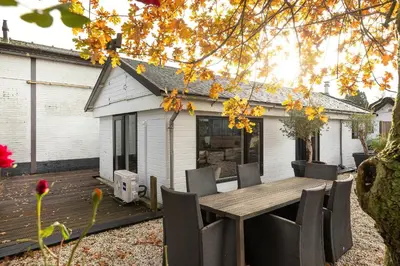 a patio with a wooden table and chairs at Woonboot De Rietpieper in Loosdrecht