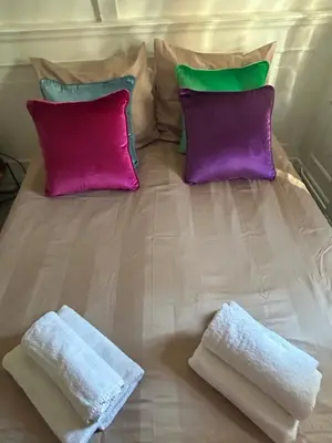 a bed with two pillows and two towels on it at Cosy by Mandy in Amsterdam
