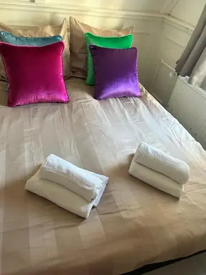 a bed with two pillows and two towels on it at Cosy by Mandy in Amsterdam