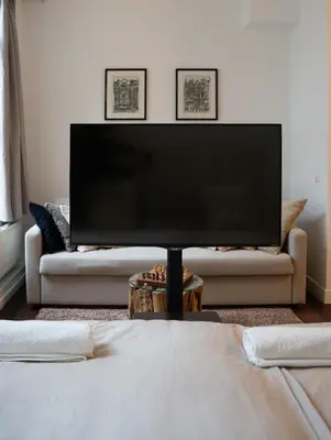 a living room with a large flat screen tv on a couch at Skinny Bridge Boutique Stay in Amsterdam