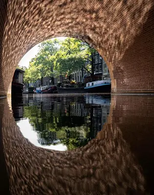a view of a canal through a brick tunnel at Skinny Bridge Boutique Stay in Amsterdam
