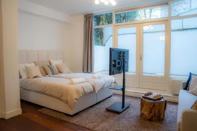 a bedroom with a bed and a tv in it at Skinny Bridge Boutique Stay in Amsterdam