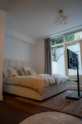 a bedroom with a large bed and a television at Skinny Bridge Boutique Stay in Amsterdam