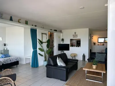 a living room with a couch and a table at Appartement Atlantis met Zeezicht in Egmond aan Zee
