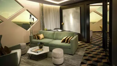 a living room with a green couch and a table at Hilton Amsterdam Airport Schiphol in Schiphol
