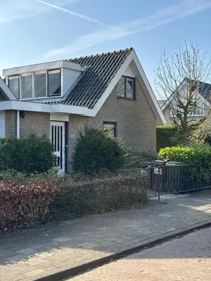 a house with a metal roof on a street at Parkzicht Zwanenburg in Zwanenburg
