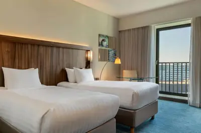 a hotel room with two beds and a balcony at Courtyard by Marriott Amsterdam Arena Atlas in Amsterdam