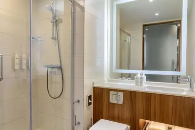 a bathroom with a shower and a toilet and a sink at Courtyard by Marriott Amsterdam Arena Atlas in Amsterdam