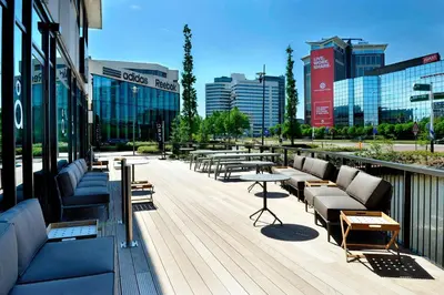 a deck with couches and tables on a building at Courtyard by Marriott Amsterdam Arena Atlas in Amsterdam