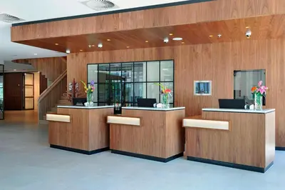 a lobby with two reception desks with laptops on them at Courtyard by Marriott Amsterdam Arena Atlas in Amsterdam