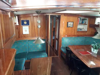 a dining car of a train with a table and chairs at Tjalkjacht Pelikaan Hoorn in Hoorn