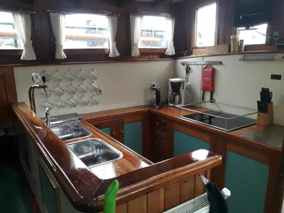 a kitchen with a sink and a stove at Tjalkjacht Pelikaan Hoorn in Hoorn