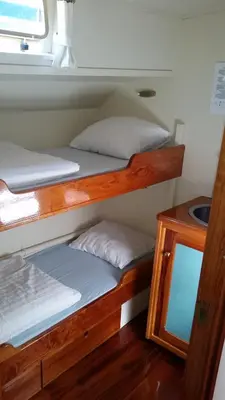 two bunk beds in a room with a mirror at Tjalkjacht Pelikaan Hoorn in Hoorn