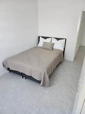 a bedroom with a bed in a white room at Smile Home Wijk aan Zee 1 in Wijk aan Zee