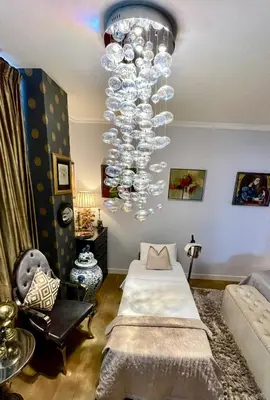 a room with two beds and a chandelier at Luxury City Center apartment with Canal view 1 kingsize bed and 1 sleeping sofa in Amsterdam