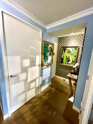 a hallway with a door and paintings on the wall at Luxury City Center apartment with Canal view 1 kingsize bed and 1 sleeping sofa in Amsterdam