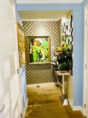 a hallway with a painting of a woman on a wall at Luxury City Center apartment with Canal view 1 kingsize bed and 1 sleeping sofa in Amsterdam