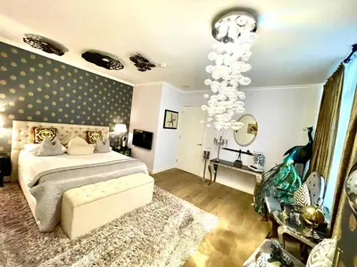 a bedroom with a bed and a chandelier at Luxury City Center apartment with Canal view 1 kingsize bed and 1 sleeping sofa in Amsterdam