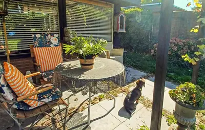 a dog sitting next to a table in a patio at Nice Home In Warmenhuizen With Wifi in Warmenhuizen