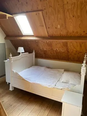 a white bed in a room with a window at heerlijk buitenhuis op 20 minuten van Amsterdam in Nieuwersluis