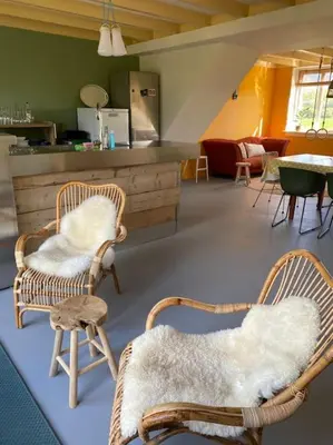 a living room with two chairs and a counter at heerlijk buitenhuis op 20 minuten van Amsterdam in Nieuwersluis