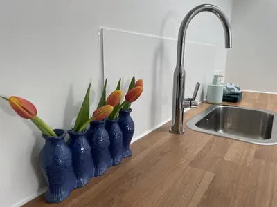 four blue vases with flowers in them on a kitchen counter at Forecastle KL in Amsterdam
