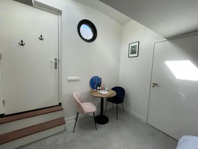 a room with a table and two chairs and a mirror at Forecastle KL in Amsterdam