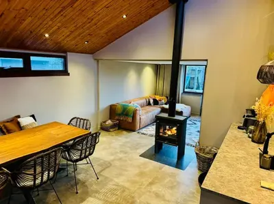a living room with a table and a fireplace at Dune Lagoon in Egmond aan den Hoef