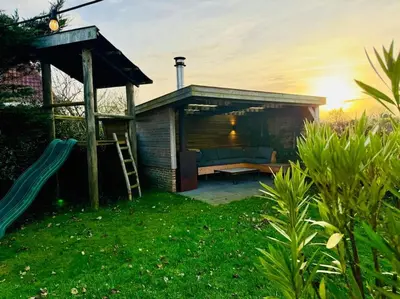 a house with a playground with a slide at Dune Lagoon in Egmond aan den Hoef