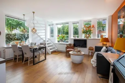 a living room with a table and a dining room at Vakantiehuis De Zeeparel in Zandvoort
