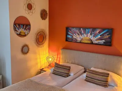 a bedroom with two beds and mirrors on the wall at Prins Appartementen in Egmond aan Zee