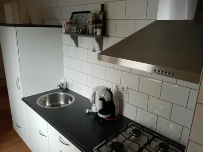 a kitchen with a sink and a counter top with a mixer at Prins Appartementen in Egmond aan Zee