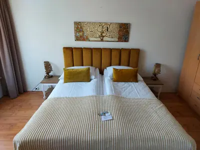 a bedroom with two beds with yellow pillows at Prins Appartementen in Egmond aan Zee
