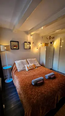 a bedroom with a large bed with two pillows on it at JoyJoyJoy the Red Sun ecolicious studio in the historic Canalhouse Tropics at the Canals from 1729 in Amsterdam