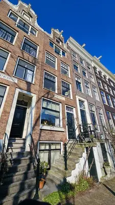 a large brick building with stairs in front of it at JoyJoyJoy the Red Sun ecolicious studio in the historic Canalhouse Tropics at the Canals from 1729 in Amsterdam