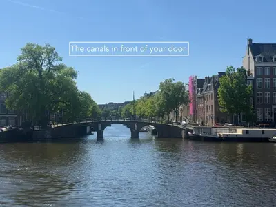 a bridge over a river in a city at JoyJoyJoy the Red Sun ecolicious studio in the historic Canalhouse Tropics at the Canals from 1729 in Amsterdam