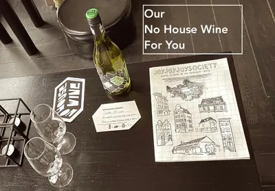 a bottle of wine and wine glasses on a table at JoyJoyJoy the Red Sun ecolicious studio in the historic Canalhouse Tropics at the Canals from 1729 in Amsterdam