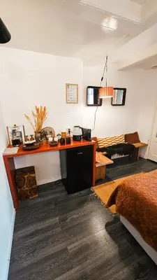 a bedroom with a desk and a bed in a room at JoyJoyJoy the Red Sun ecolicious studio in the historic Canalhouse Tropics at the Canals from 1729 in Amsterdam