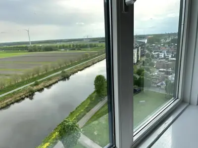 a window with a view of a river at Luxe Penthouse Met Panorama Uitzicht Op Natuur in Almere