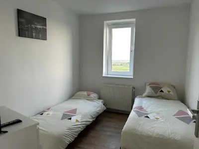 two beds in a room with a window at Luxe Penthouse Met Panorama Uitzicht Op Natuur in Almere