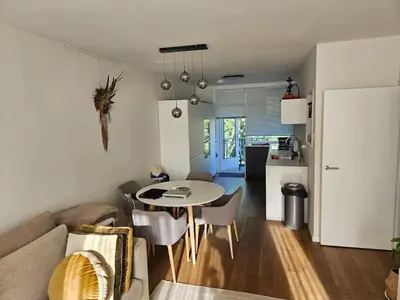 a living room with a table and a kitchen at The Amsterdam - South Apartment in Amsterdam