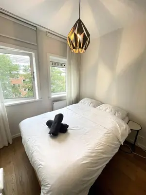a bedroom with a bed with a black object on it at The Amsterdam - South Apartment in Amsterdam